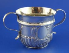 A Queen Anne silver porringer by Thomas Parr I, with wrythened fluted body, banded girdle and reeded