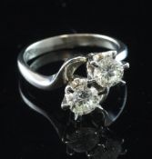 An 18ct white gold and two stone diamond crossover ring, the two round brilliant cut stones with