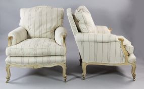 A pair of Louis XV style carved beech upholstered armchairs, upholstered in beige and red stripe