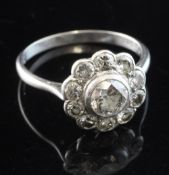 A 1920's platinum and diamond cluster ring, of flowerhead design, with millegrain setting, the