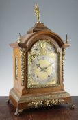 An early 20th century ormolu mounted oak bracket clock, of architectural form with arched brass dial