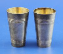 A pair of late 19th century Russian 84 zolotnik silver tumblers, of tapering form with reeded bands,