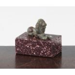 A small Roman bronze figure of a recumbent lion, c.2nd century AD, 3.5cm, together with a porphyry