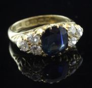 An early George V 18ct gold, sapphire and diamond ring, with carved setting and central sapphire