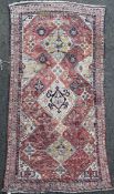 A Turkish rug, with three central diamond medallions in a field of geometric motifs including