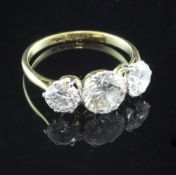 An 18ct gold and platinum three stone diamond ring, the central round cut stone weighing
