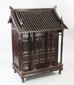 A Chinese stained elm shrine cabinet, 19th century, with ribbed pitched roof, four hinged doors