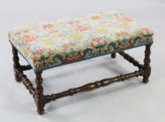 A late 17th century rectangular walnut stool, upholstered in blue floral patterned fabric, with