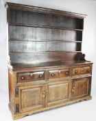 A George III fruitwood dresser, with fitted open shelves, three short drawers and pair of panelled