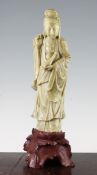 A Chinese pale green soapstone figure of Guanyin, 20th century, standing holding a vase in her