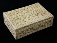 A Chinese ivory box, late 19th century, carved in relief with figures amid pavilions and trees on