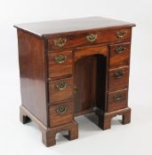 A mid 18th century mahogany kneehole desk, the moulded top with re-entrant corners, with central