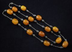 A single strand amber bead and filligree white metal necklace, with fourteen amber beads. gross