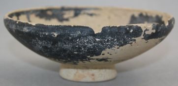 A Greek blackware pottery bowl, Apulia c.4th / 3rd century BC, of shallow curved and a circular