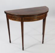 A George III mahogany and crossbanded demi lune folding card table, with tapered legs and spade