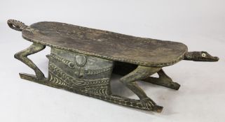 A Papua New Guinea Sepik River wooden ceremonial low table or bench, carved as a standing