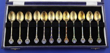 A cased set of twelve 1970's silver gilt and enamel coffee spoons, with enamelled stems and