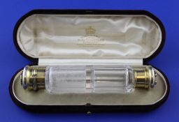A Victorian silver gilt and panelled glass double ended scent bottle, the two lids decorated with
