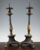 A pair of French Empire style patinated bronze and ormolu pricket candlesticks, the fluted columns