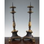 A pair of French Empire style patinated bronze and ormolu pricket candlesticks, the fluted columns