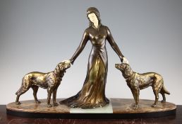 A French Art Deco patinated metal and ivorine figure group of a standing female and two attendant