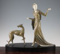 A French Art Deco patinated metal and ivorine figure group, of a lady and dog, on oval black