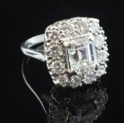 A 1940's/1950's 18ct white gold and diamond cluster ring, with central emerald cut diamond