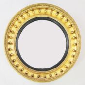 A large 19th century circular convex gilt wall mirror, the frame applied with a row of ball