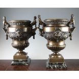 A pair of French Egyptian revival bronze urns, the lion mask handles mounted with sphinx, the