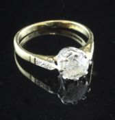 An 18ct gold single stone diamond ring, with diamond set shoulders, the central stone weighing