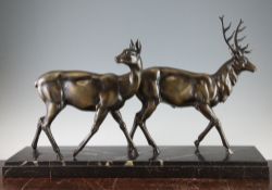 A French Art Deco patinated metal figure group of a stag and doe, on rectangular marble base, 27.