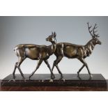 A French Art Deco patinated metal figure group of a stag and doe, on rectangular marble base, 27.