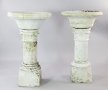 A pair of marble gardens urns, the circular bowls above a central column with stylised leaf