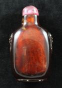 A Chinese amber snuff bottle, 1760-1860, of rounded rectangular form, with a pair of lion mask