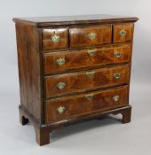 A mid 18th century walnut and pine chest, of three short and three long featherbanded drawers, on