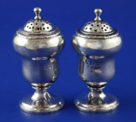 A pair of William IV silver pedestal salt and pepper pots, of acorn shape, with engraved monogram,