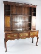 A mid 18th century oak and mahogany crossbanded dresser, the plate rack fitted with shelves,