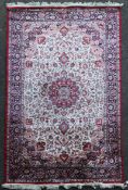 A Turkish part silk rug, with central foliate medallion within a field of scrolling foliage, on a