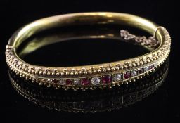 A late Victorian 15ct gold, ruby and diamond set hinged bracelet, set with fifteen graduated