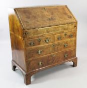 An early 18th century walnut and featherbanded bureau, the fall front revealing a stepped interior