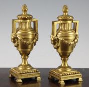 A pair of early 20th century ormolu cassolettes, modelled as twin handled urns with floral swags and