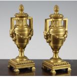 A pair of early 20th century ormolu cassolettes, modelled as twin handled urns with floral swags and
