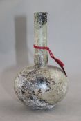 A Roman clear glass flask, c.1st / 2nd century AD, with globular body and cylindrical neck, with