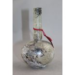 A Roman clear glass flask, c.1st / 2nd century AD, with globular body and cylindrical neck, with