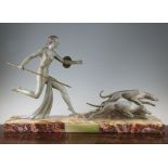 A French Art Deco patinated metal model of Diana the huntress, with two dogs, on a rectangular