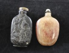 Two Chinese crystal snuff bottles, 1850-1920, the first in hair crystal carved in relief to one side