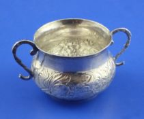 A Charles II silver porringer, with scroll handles and engraved initials and embossed with