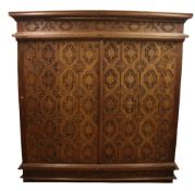 A large Burmese carved hardwood cabinet, with hinged doors revealing fitted drawers, W.7ft 4in.