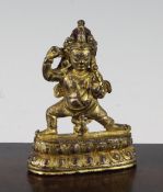 A Tibetan gilt copper bronze figure of Mahakala, 18th / 19th century, standing on a double lotus