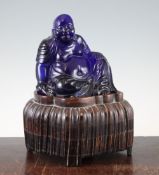 A Chinese Beijing blue glass seated figure of Budai, late 19th / early 20th century, 15.5cm,